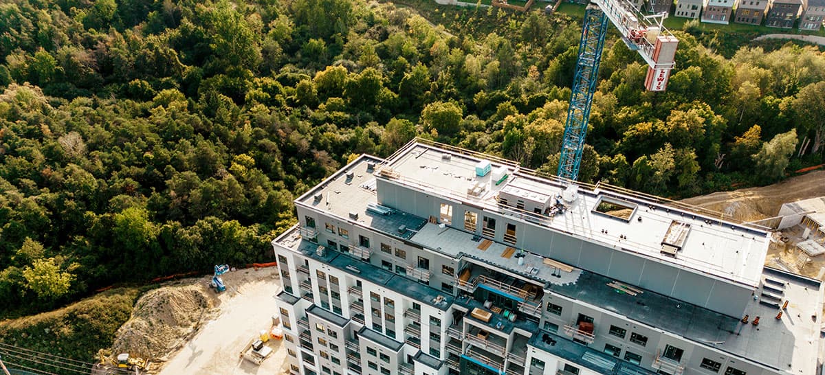 Construction crane on top of a partially built apartment building